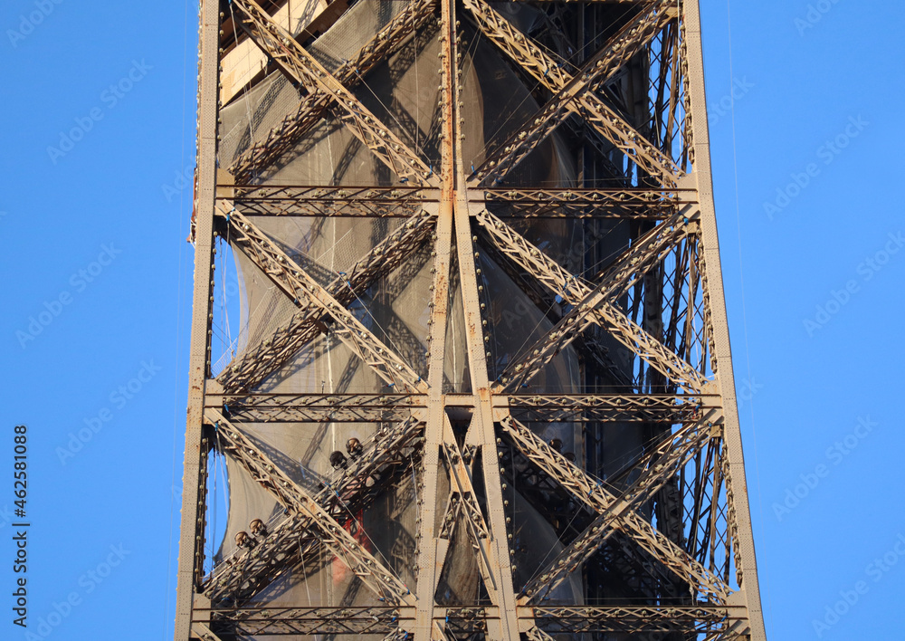 Fragments of the eiffel tower in Paris, illuminated by the evening sun, at the golden hour