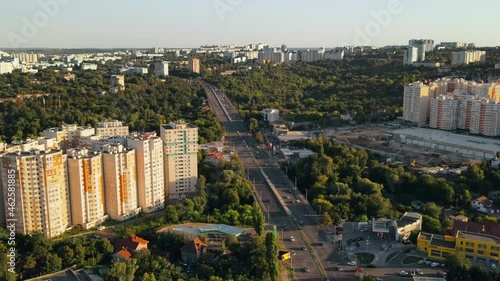 Aerial drone view of Chisinau at sunset. Multiple buildings, road and bridge with cars. Park with greenery photo
