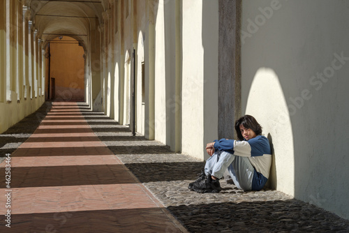 Teenage girl sitting on the street of the Italian old town