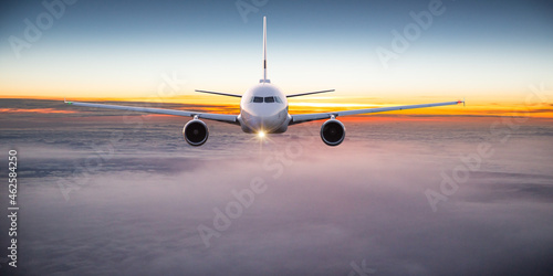 Commercial airplane flying above dramatic clouds.
