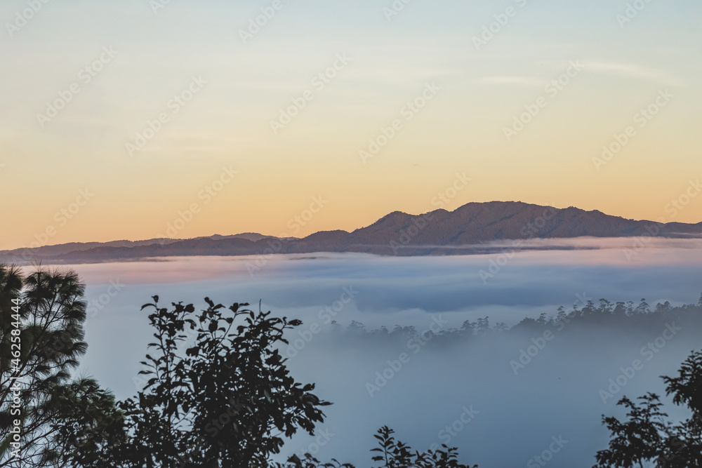 Autumn foggy mountains landscape with colorful sky in morning,