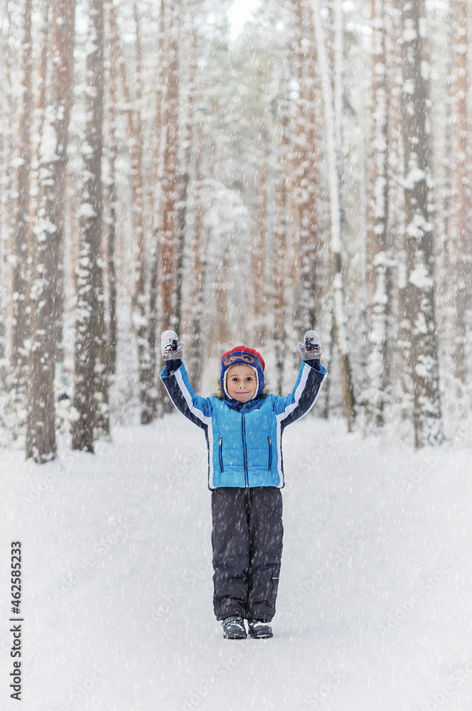 Little boy in a blue outwear having fun in the forest