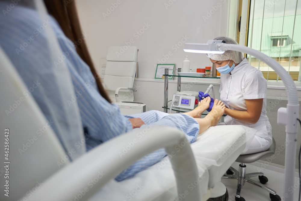 Fototapeta premium Woman in pedicure salon getting her feet peeled