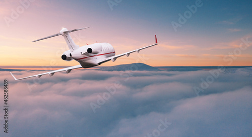 Private jetplane flying above dramatic clouds