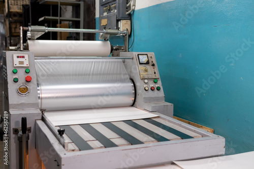 Industrial laminator, lamination of paper products. The manufacture of packaging. Outdated equipment. Company. Place for text. photo