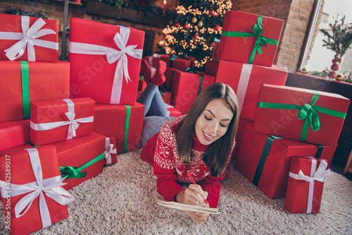 Photo of cute pretty lady lay floor hold pencil write wish-list dream wear pullover in decorated x-mas home indoors