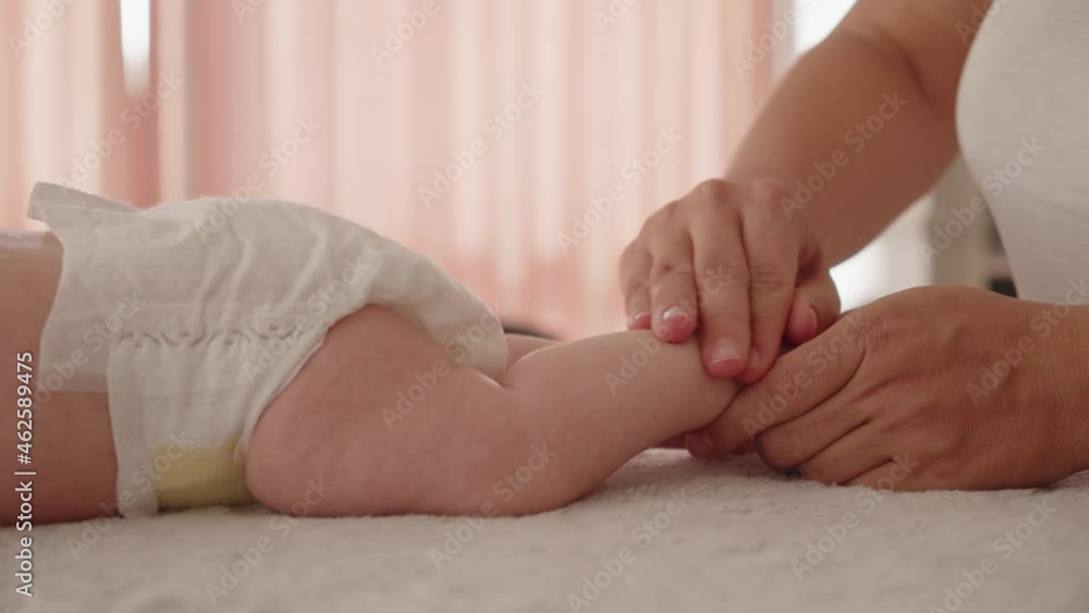 Masseuse performing a massage for infant's small feet and developing toes. masseuse doing massage for a healthy small baby. Small caucasian newborn. Masseuse performing a massage for infant's small feet and developing toes. masseuse doing massage for a healthy small baby. Small caucasian newborn.