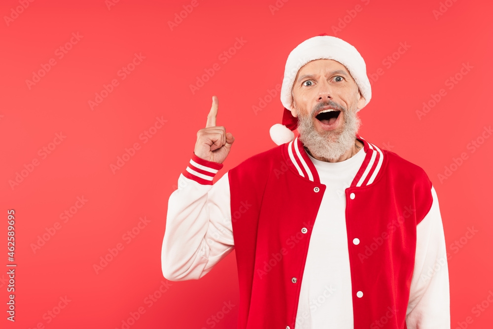 amazed man in santa hat having idea isolated on red amazed man in santa hat having idea isolated on red
