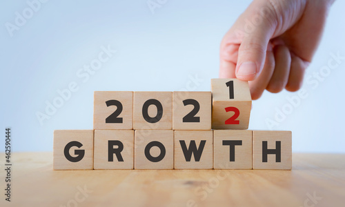 Business growth concept in 2022 for business plan and strategy. Hand flips wooden cubes "2021" to "2022" text on beautiful background and copy space. Banner for the new action plan ,annual plan.