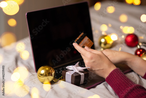 woman orders christmas gifts over the Internet. holding a credit card