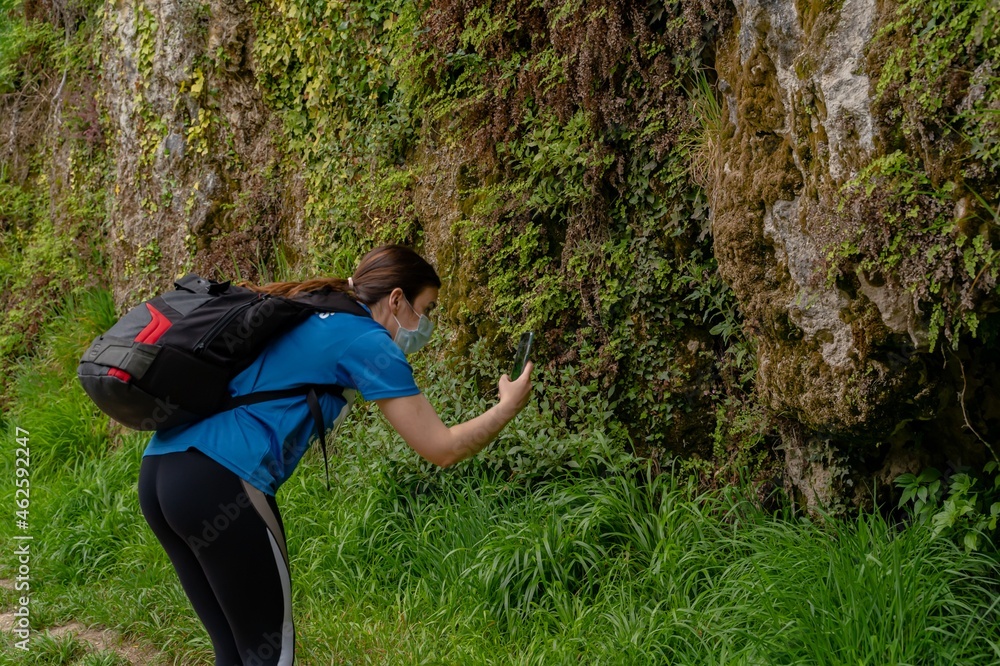 Young girl makes photo with her smartfhone in nature