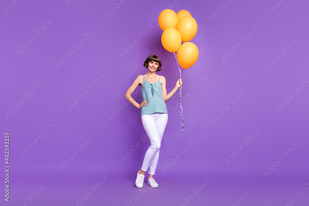 Full length body size view of attractive cheerful girl holding balls isolated over bright violet purple color background