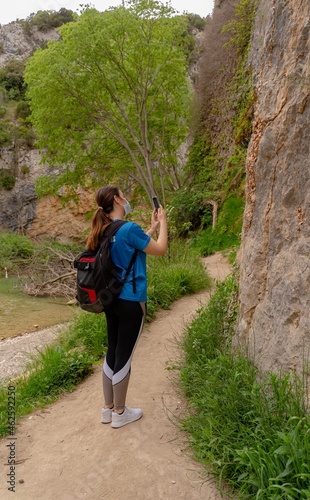 Obraz na płótnie Woman in nature photographing the landscape with her smartphone w salonie