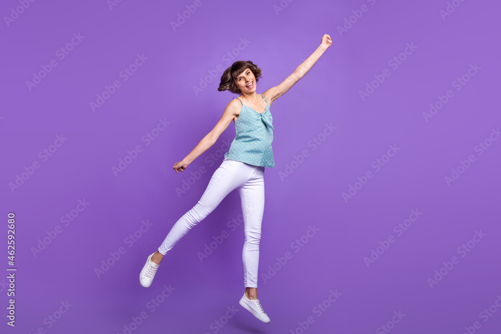 Full length body size view of lovely cheerful girl jumping holding copy space isolated over bright violet purple color background
