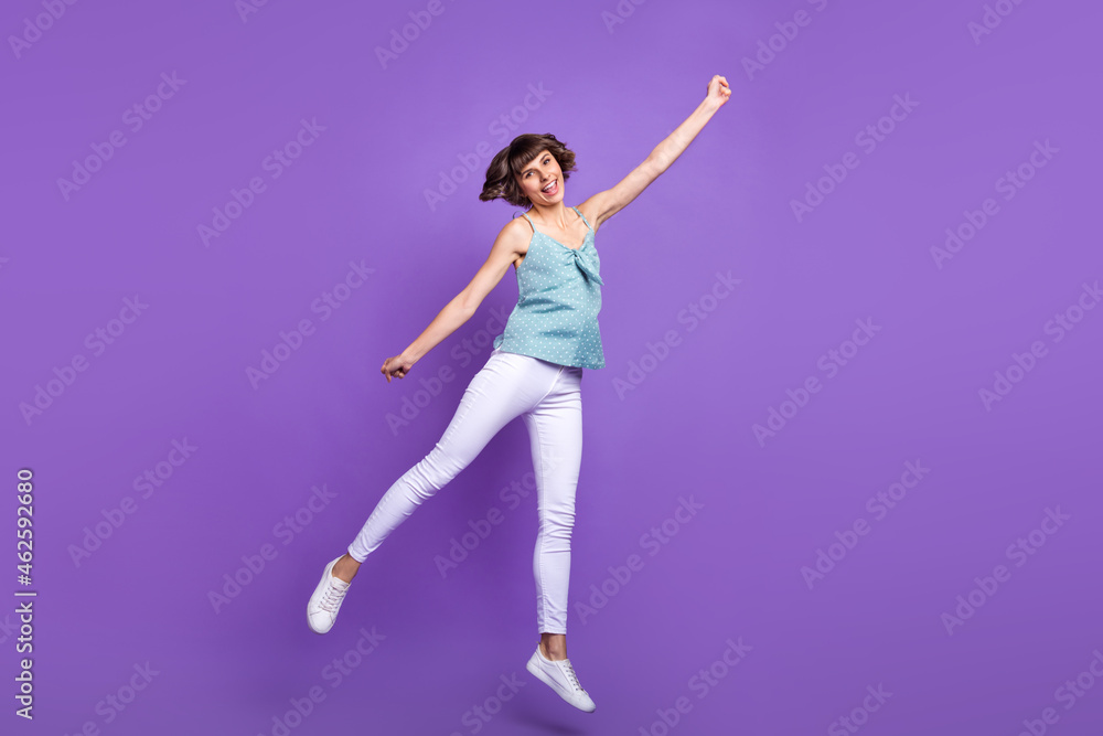 Full length body size view of lovely cheerful girl jumping holding copy space isolated over bright violet purple color background Full length body size view of lovely cheerful girl jumping holding copy space isolated over bright violet purple color background
