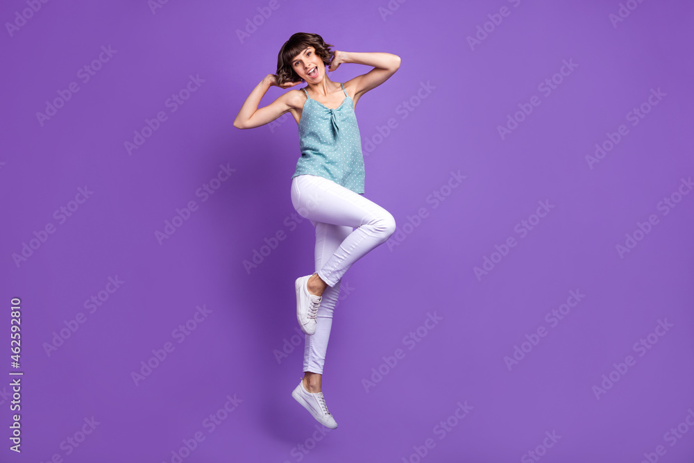 Full length body size view of attractive cheerful carefree girl jumping rest isolated over bright violet purple color background Full length body size view of attractive cheerful carefree girl jumping rest isolated over bright violet purple color background