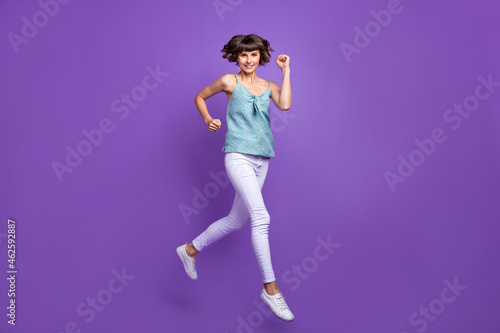 Full length body size view of attractive cheerful girl jumping running isolated over bright violet purple color background