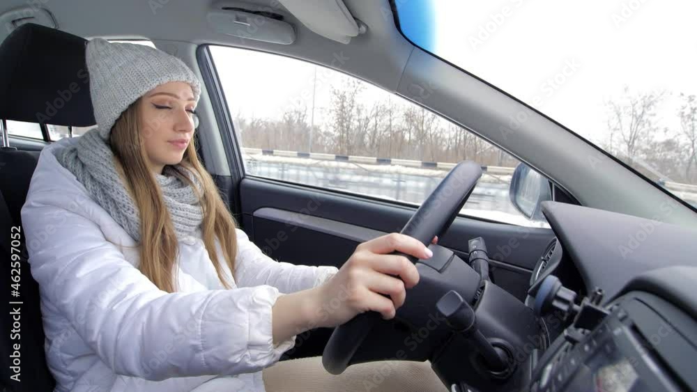Winter road trip. Profile of a young female driver, a young blonde driving a car. Side view. A traveling girl. Portrait of a happy young Caucasian businesswoman sitting alone in the driver's seat Winter road trip. Profile of a young female driver, a young blonde driving a car. Side view. A traveling girl. Portrait of a happy young Caucasian businesswoman sitting alone in the driver's seat