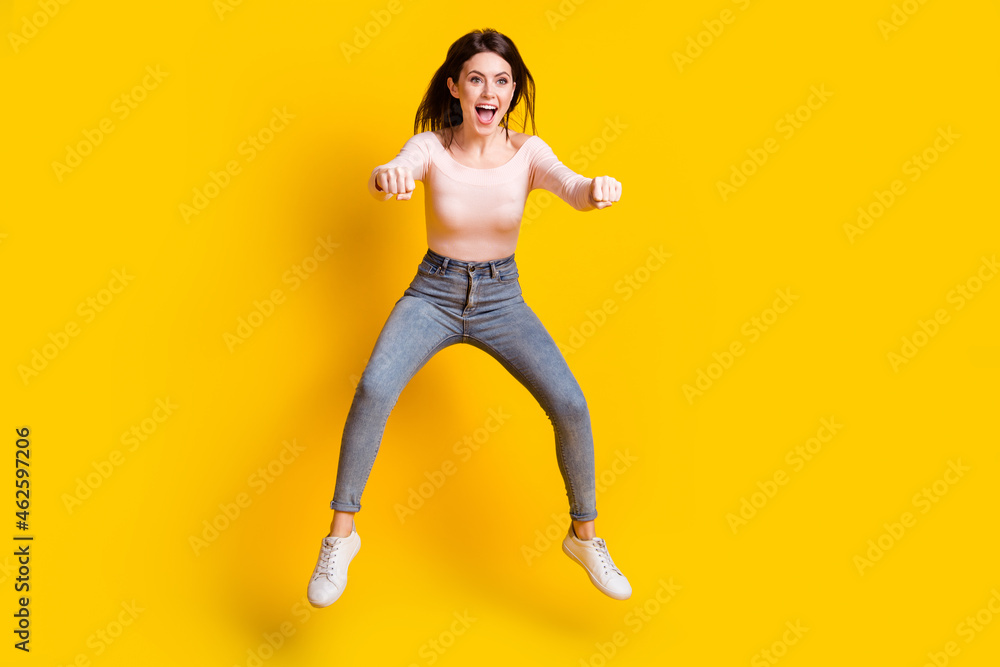 Full size photo of young happy excited woman look copyspace riding invisible moped isolated on yellow color background Full size photo of young happy excited woman look copyspace riding invisible moped isolated on yellow color background