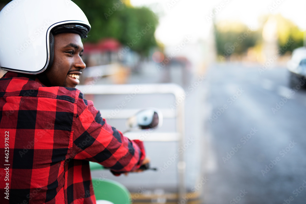 Handsome African man with scooter in the city. Young man riding a scooter Handsome African man with scooter in the city. Young man riding a scooter