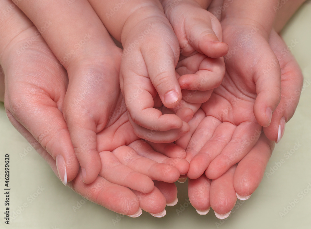 The hands of a mother and two children are folded together. The concept of Family, Parental Love, Happiness, Care, Responsibility, Childbirth The hands of a mother and two children are folded together. The concept of Family, Parental Love, Happiness, Care, Responsibility, Childbirth