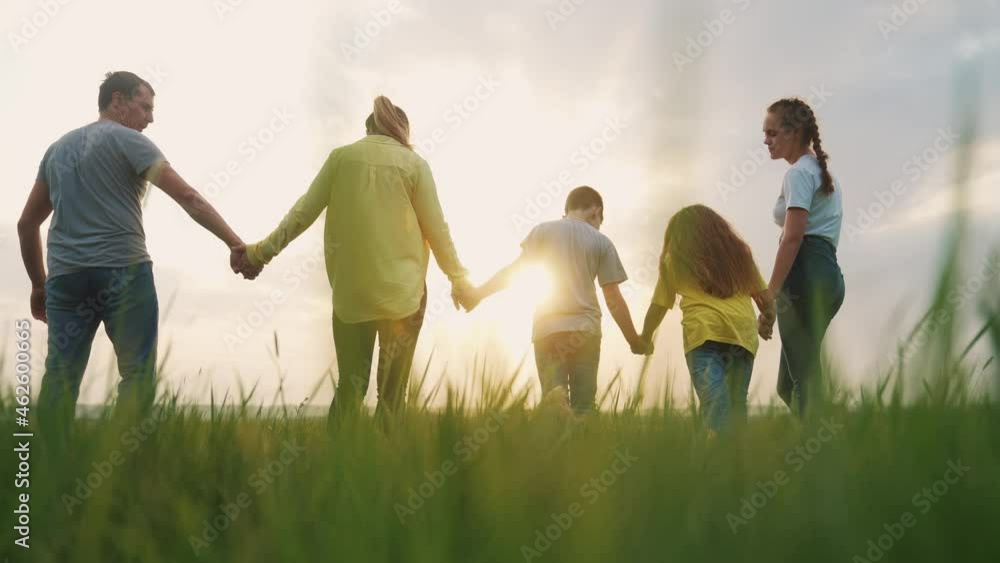 people in the park. happy family a silhouette walk in field. mom dad and daughters, son walk holding hands in park. happy family kid dream concept. parents and children walking back silhouette fun people in the park. happy family a silhouette walk in field. mom dad and daughters, son walk holding hands in park. happy family kid dream concept. parents and children walking back silhouette fun