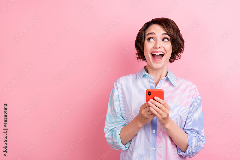 Photo of young excited woman happy positive smile type cellphone social news look empty space isolated over pink color background Photo of young excited woman happy positive smile type cellphone social news look empty space isolated over pink color background