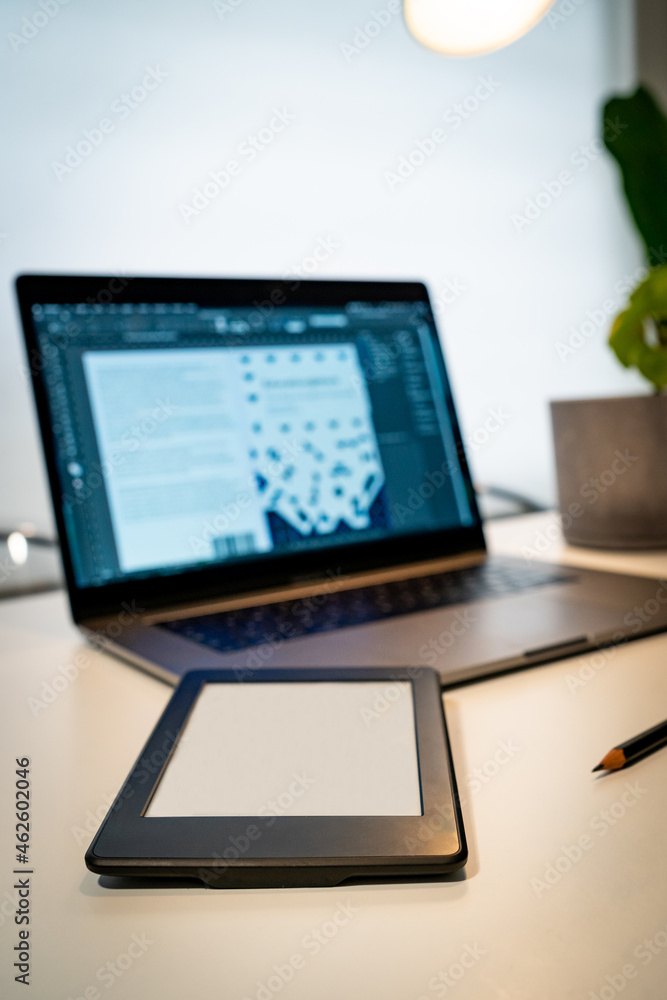 Fototapeta premium work space with laptop and e-book for synchronize workflow