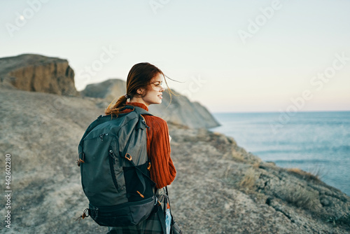 woman with backpack on her back rocky mountains landscape sea travel