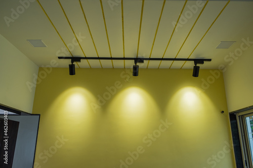 track rail spot lights on yellow wall for interior designing