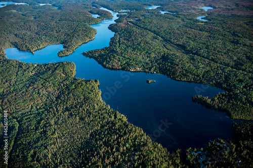 Aerial view of lake hidden amongst thick lush forest. © Cody