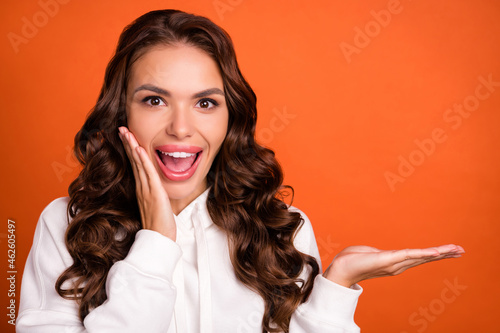 Photo of young excited girl surprised reaction wow discount advertise offer black friday isolated over orange color background photo