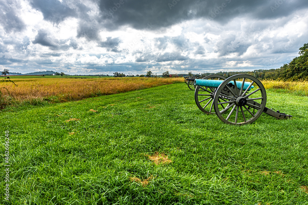 Φωτογραφία Civil War cannon in front of colorful field with beautiful clouds in the autumn