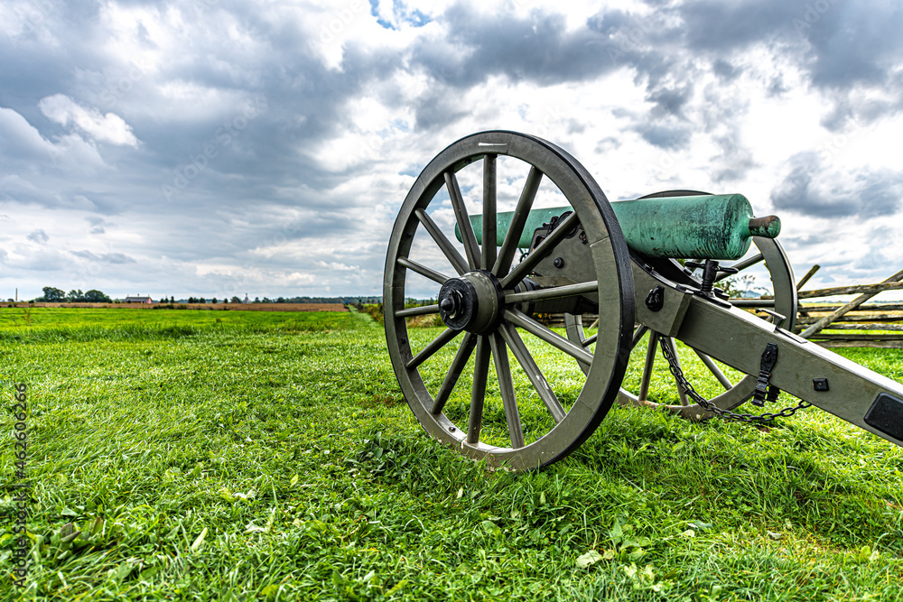 Civil War cannon in front of colorful field with beautiful clouds in the autumn 