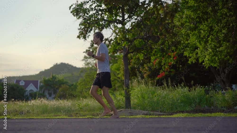Slow Motion shot of a young man running barefoot. Barefoot running concept Slow Motion shot of a young man running barefoot. Barefoot running concept
