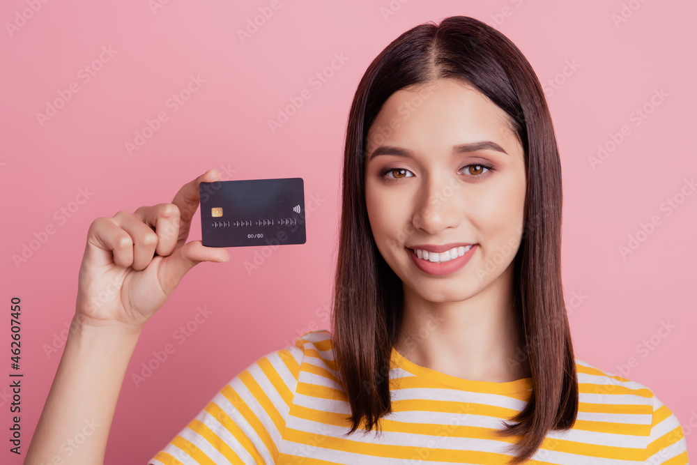 Portrait of nice attractive lady showing credit card toothy smile on pink background Portrait of nice attractive lady showing credit card toothy smile on pink background