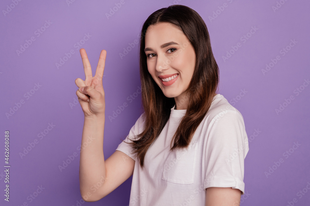 Profile side photo of young girl happy positive smile show peace cool v-sign isolated over violet color background Profile side photo of young girl happy positive smile show peace cool v-sign isolated over violet color background