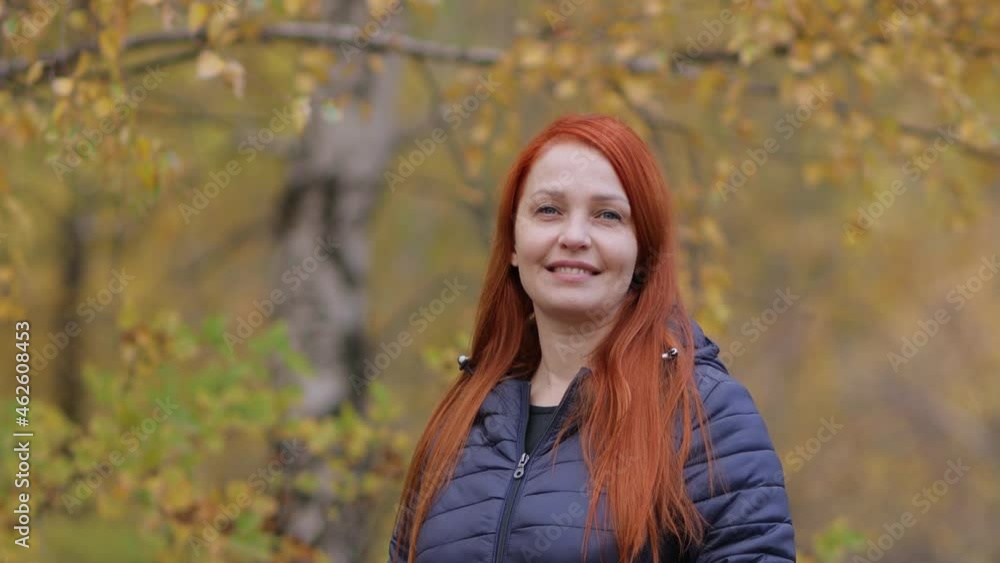 portrait of a life style woman with red hair in autumn against a background of colorful foliage portrait of a life style woman with red hair in autumn against a background of colorful foliage