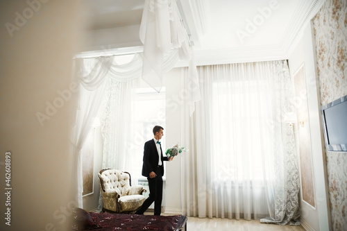 Grooms morning preparation. Handsome man getting dressed and preparing for the wedding photo