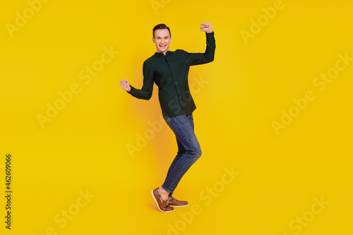 Full body profile side photo of young guy celebrate victory success fan champion isolated over yellow clor background