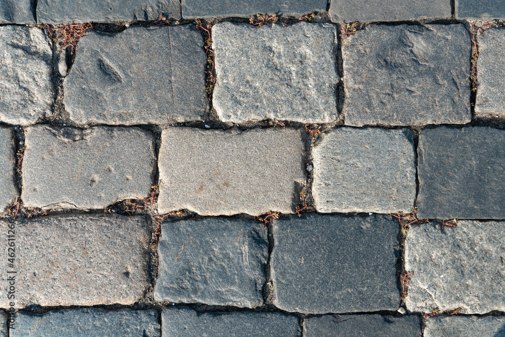 Old paving stones with chips and potholes in the city square texture or background Old paving stones with chips and potholes in the city square texture or background