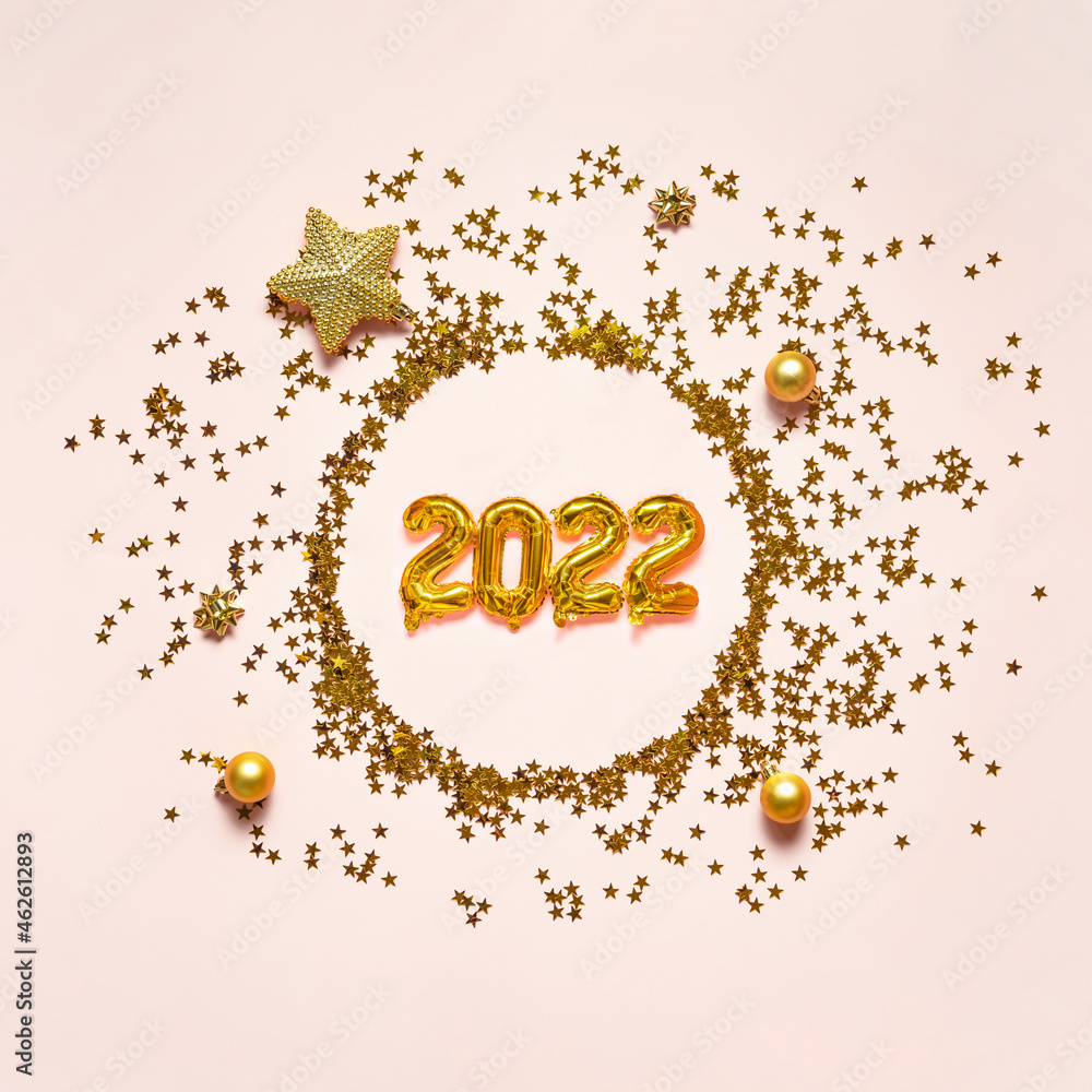 Christmas composition. Wreath of golden stars and gold foil balloons 2022 on pink background. Christmas holiday concept Christmas composition. Wreath of golden stars and gold foil balloons 2022 on pink background. Christmas holiday concept