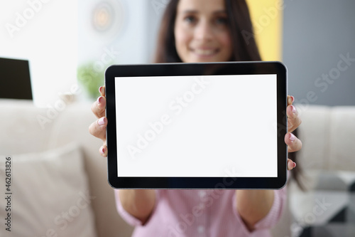 Young woman holding in hands and showing digital tablet closeup