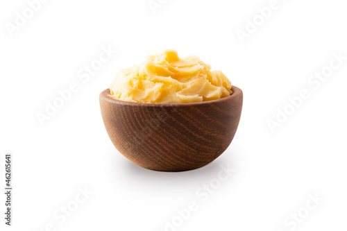 Ghee or clarified butter in wooden bowl, cooking oil, pure ghee isolated on white background. Clarified butter with copy space for text on white.