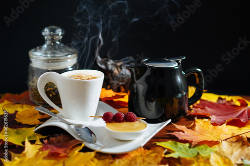 Autumn tea. Cup of tea with maple autumn leaves honey ruspberry and elephant on wooden table. autumn mood. Autumn style life photo