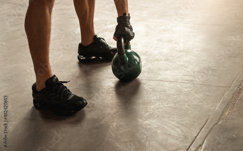 Sporty man exercising with kettlebell in gym