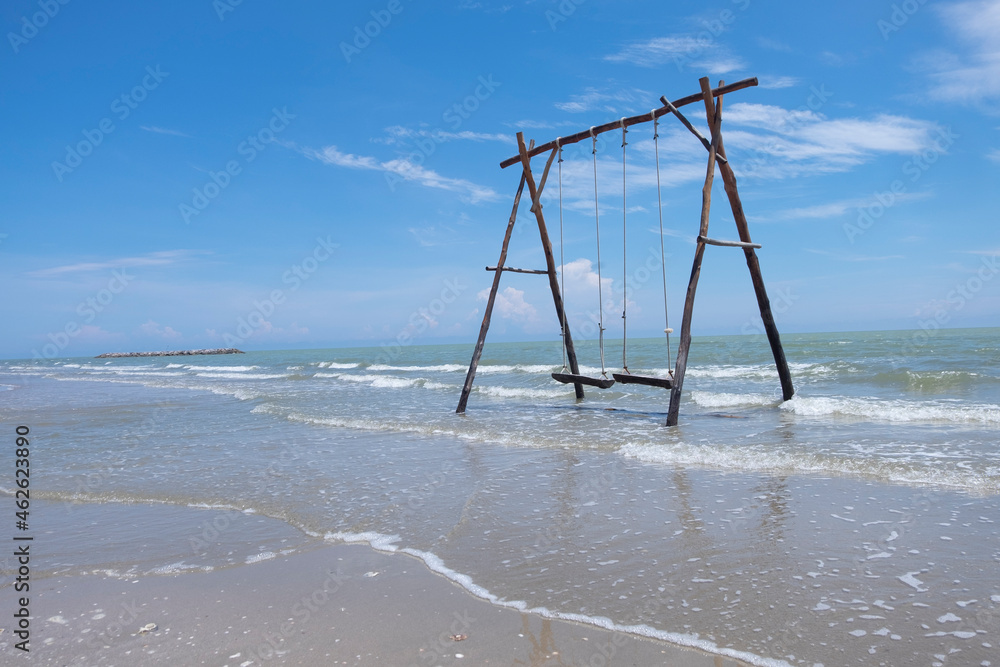 large wooden swing Placed on the beach where the sea is flooded. large wooden swing Placed on the beach where the sea is flooded.