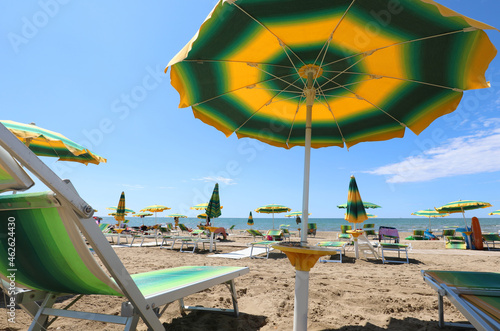 Deckchair on the beach under the umbrella during a hot summer day photo