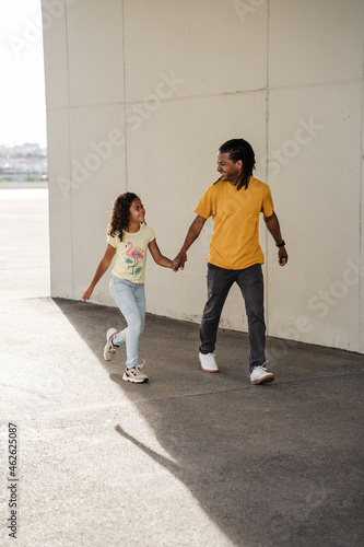 Vertical shoot of dominican father and son walking and smiling