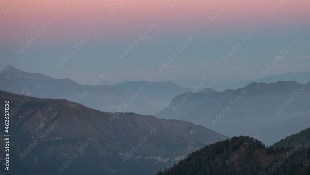 Autumn on the Alps in Italy, the landscape of the woods and mountains with colored foliage. The blue hour on the mountain.